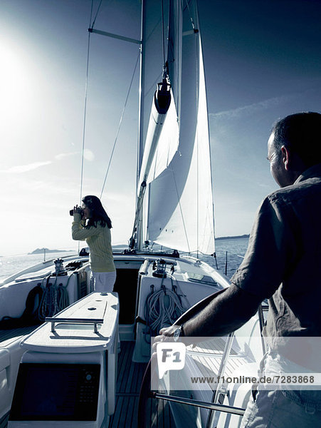 Couple on yacht with binoculars