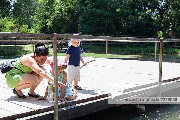 Mutter und Kinder untersuchen den Fluss