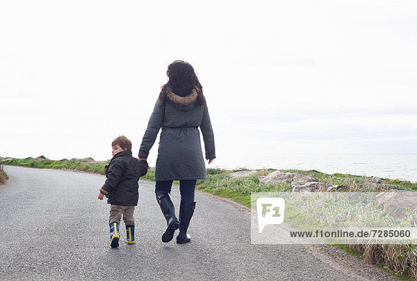 Mother and son walking on rural road