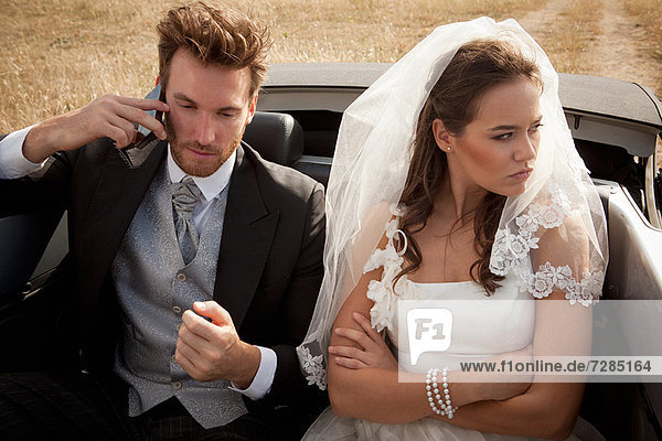 Newlywed couple arguing in car