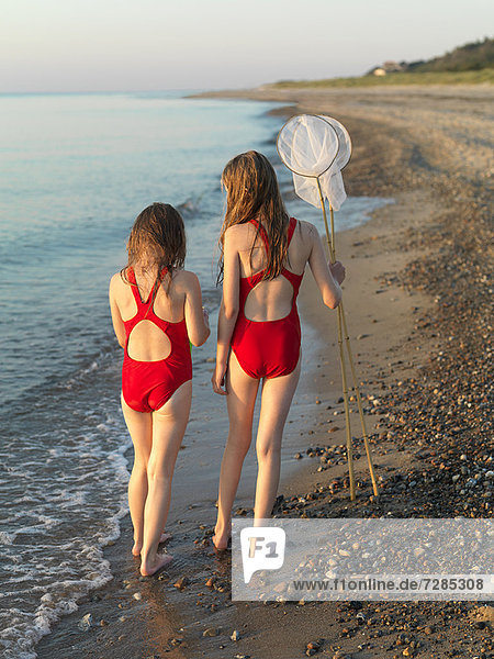 Girls walking on rocky beach