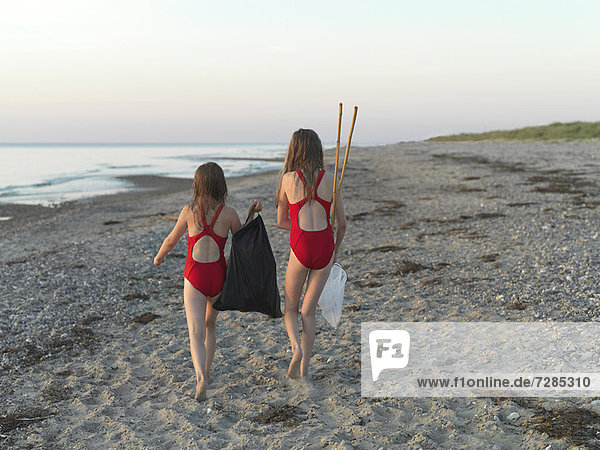 Girls walking on sandy beach