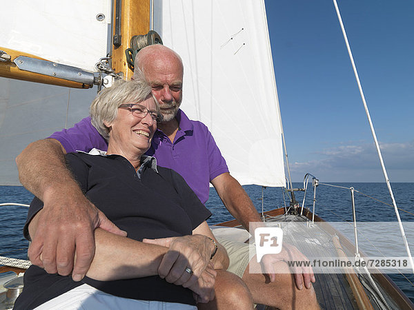 Older couple relaxing on sailboat