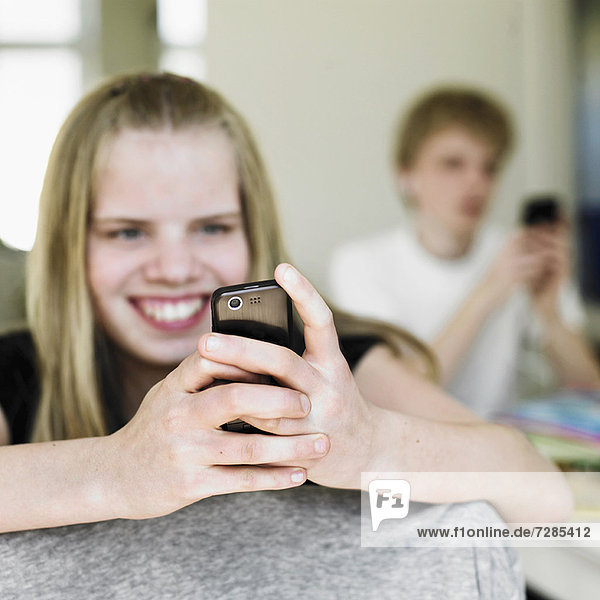 Smiling girl using cell phone