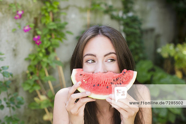 Smiling woman playing with watermelon