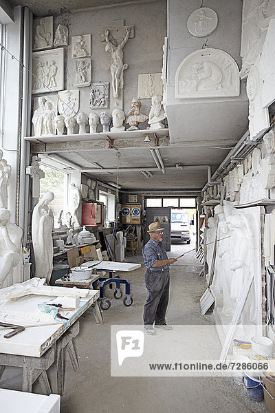Worker standing in relief carving shop