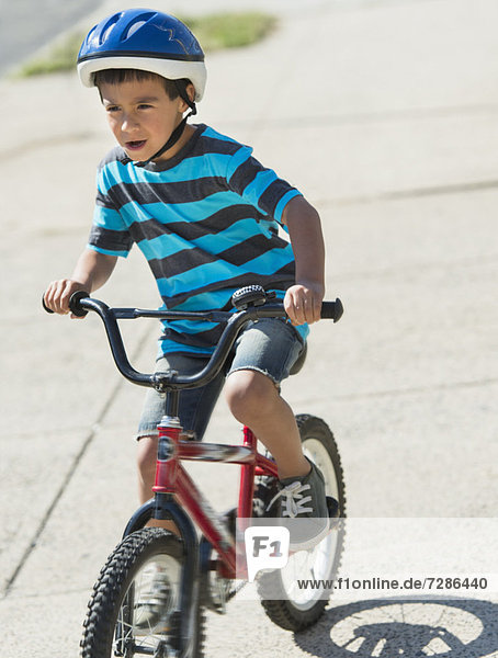 Boy (6-7) riding bicycle
