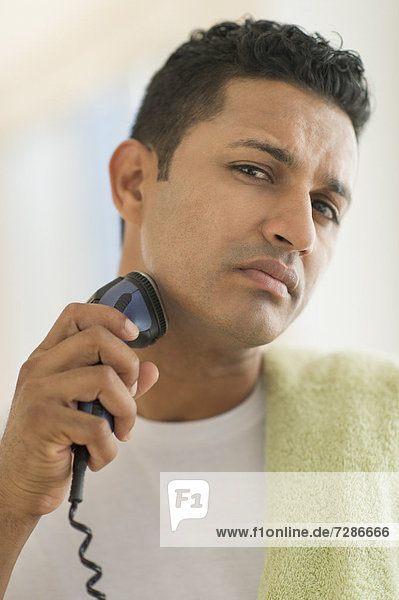 Mann mit elektrischen Rasiermesser rasieren