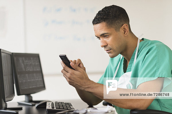 Surgeon working on computer and text messaging
