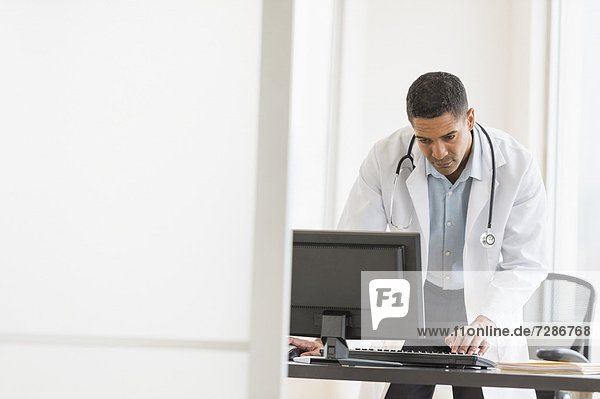 Male doctor using computer in his office