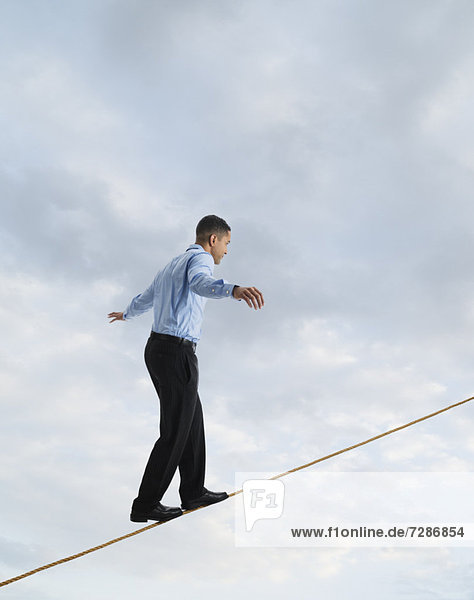 Man balancing on tightrope  studio shot