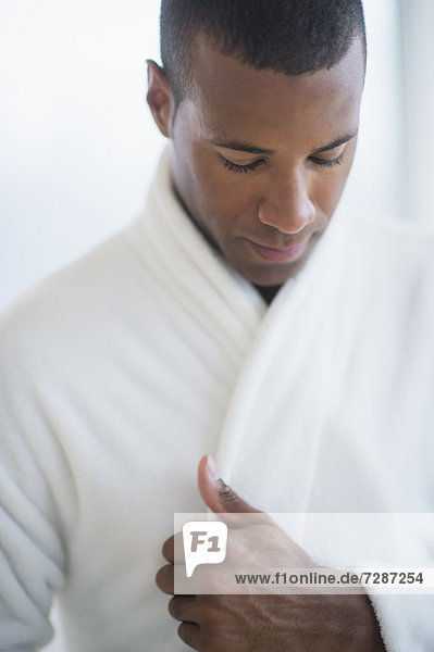 Portrait of young man in white bathrobe