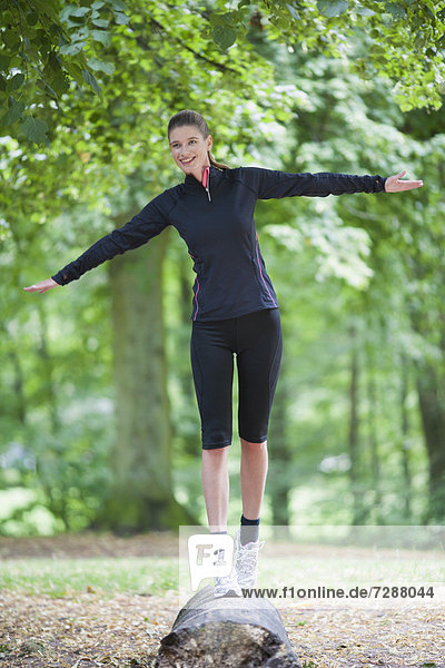 Junge Frau balancieren auf log