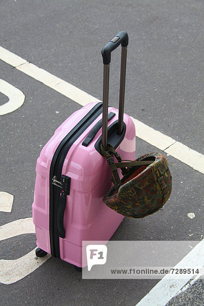 Pink suitcase with a combat helmet of the German armed forces  Germany  Europe
