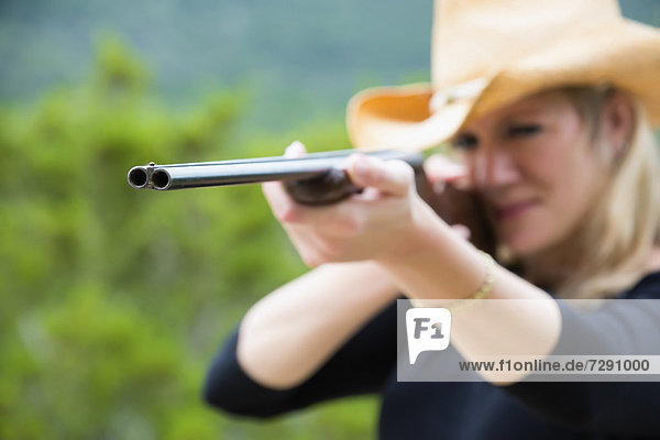 USA  Texas  Mid adult woman aiming rifle