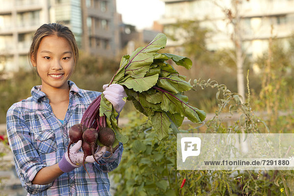 Japanese girl holding bunch of beets