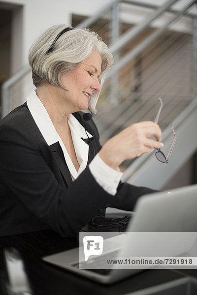 Businesswoman sitting in office with laptop