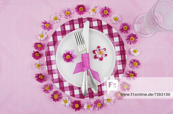 Place setting with daisy flower on tablecloth