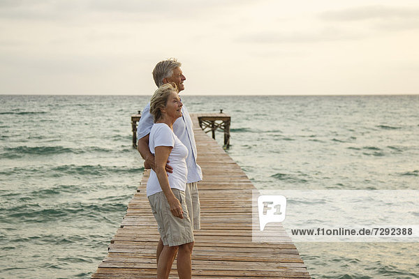 Spain  Senior couple standing on jetty at the sea
