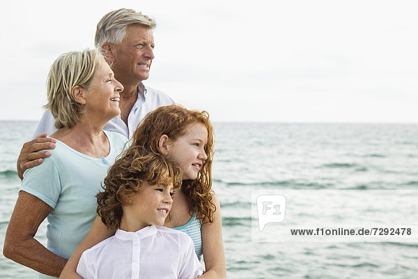 Spanien  Großeltern mit Enkeln am Meer  lächelnd  Portrait