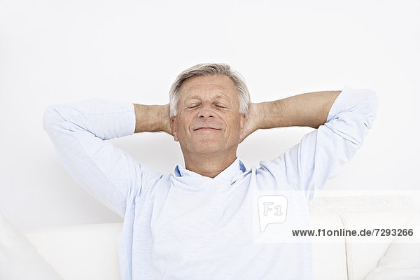 Spain  Senior man relaxing on couch  smiling