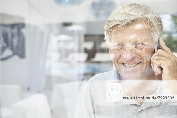 Spain  Senior man talking on mobile  smiling