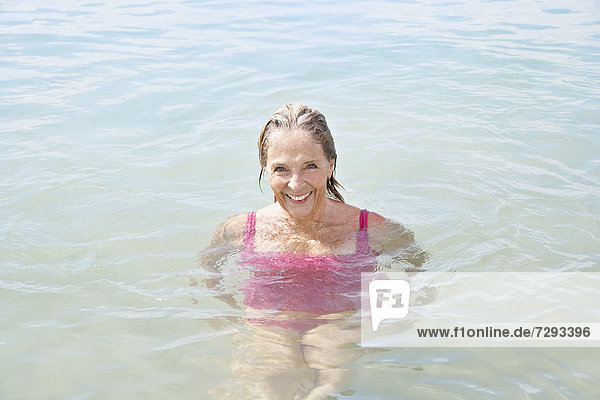 Spain,  Senior woman swimming in sea