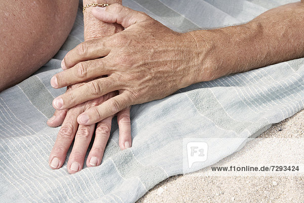 Spanien,  Mallorca,  Seniorenpaar mit Händchen am Strand