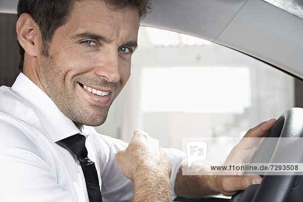 Spanien  Geschäftsmann im Auto sitzend  lächelnd  Portrait