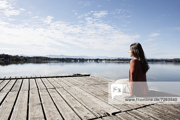 Young woman sitting on jetty