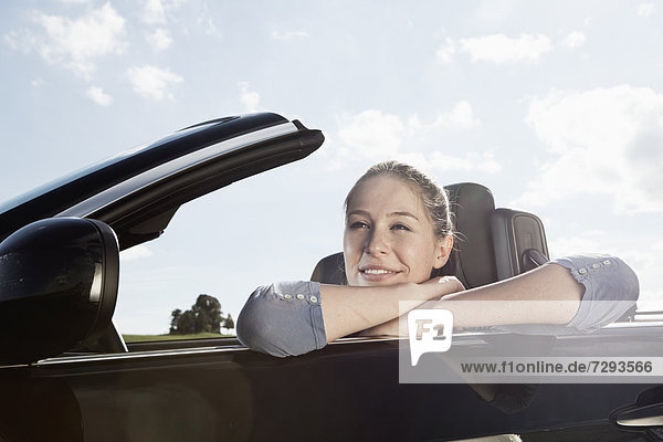 Young woman in car  smiling