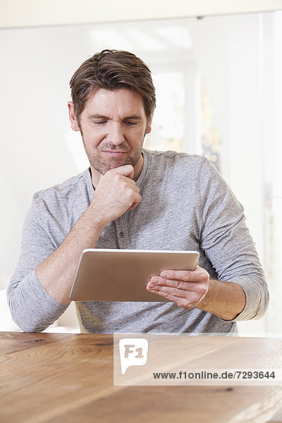 Man using digital tablet at table