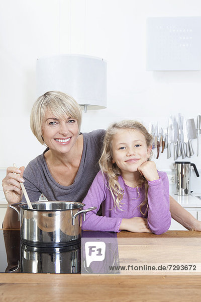 Germany,  Bavaria,  Munich,  Mother and daughter preparing food,  smiling,  portrait