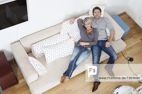 Germany  Bavaria  Munich  Mature couple relaxing on sofa