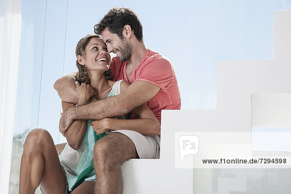 Spanien  Mittleres erwachsenes Paar auf der Treppe sitzend  lächelnd
