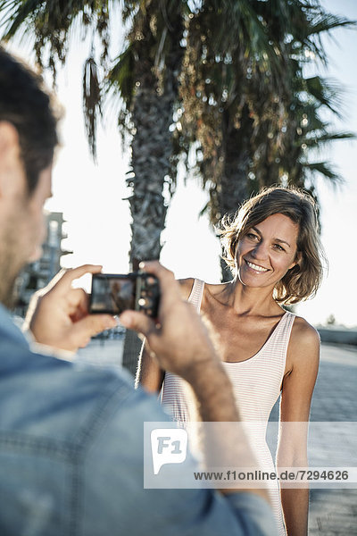 Spain,  Mid adult man taking photograph of woman