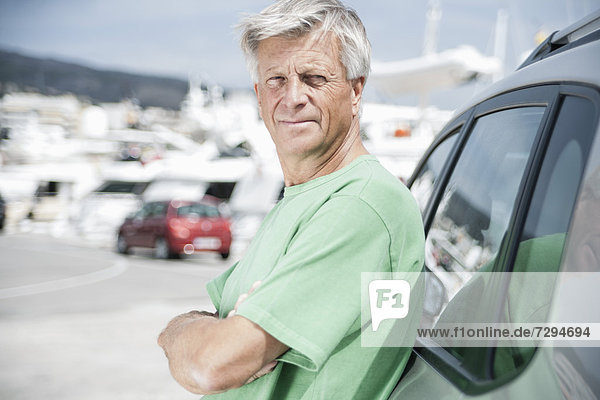 Spanien,  älterer Mann,  der sich auf das Auto stützt
