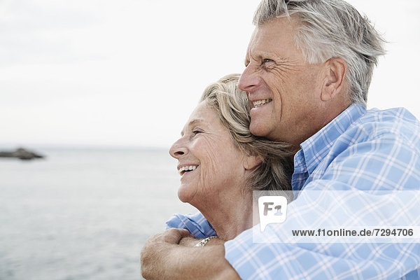 Spanien  Seniorenpaar umarmt den Hafen  lächelnd