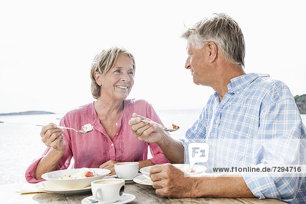 Spain  Senior couple having lunch  smiling