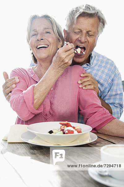 Spain  Senior couple having lunch  smiling