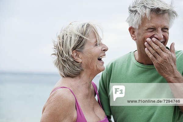 Spanien  Seniorenpaar lächelt am Strand