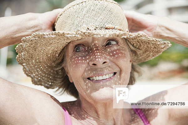 Spain  Senior woman with straw hat  smiling
