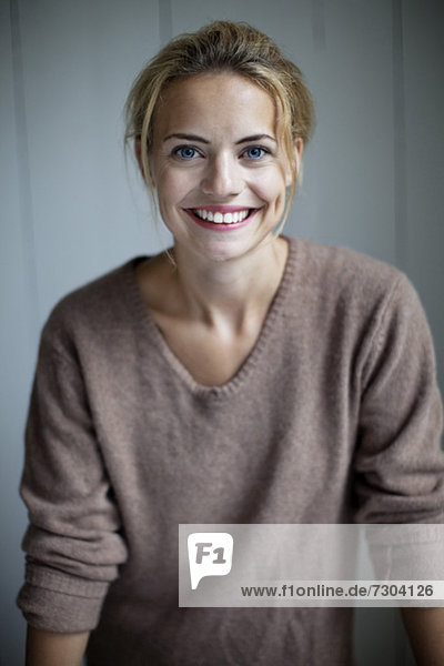 Portrait of happy young woman in sweater smiling