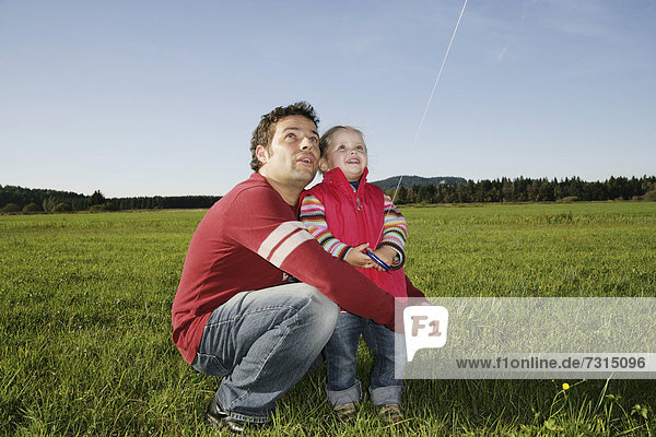 Vater und Tochter (3 Jahre) spielen mit einem Drachen