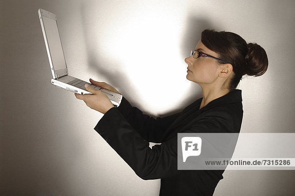 Businesswoman  aged 24  holding a laptop