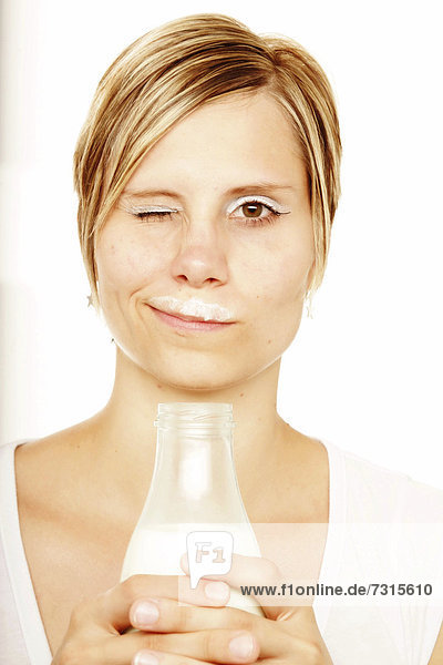 Frau mit Milchflasche und Milchbart