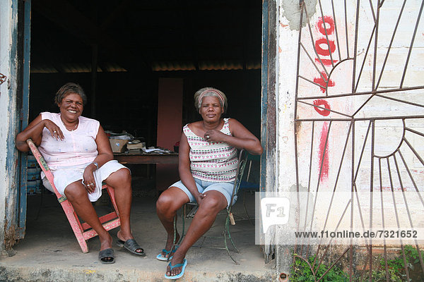 Two woman sitting in front of a community centre in Vinales  Pinar del RÌo Province  Cuba  Latin America