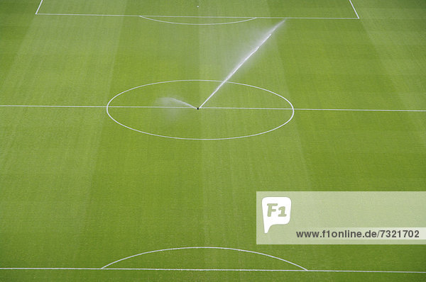 Wassersprenger im Anstoßkreis auf einem Fußballfeld