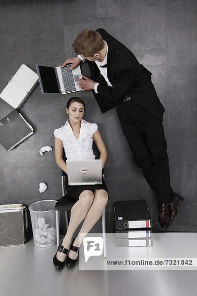 Sitting businesswoman and businessman on the floor  irritating perspective