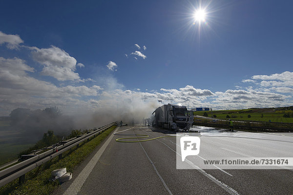 'Firefighters extinguishing a truck fire on the A8 motorway near the ''Echterdinger Ei'' junction  Stuttgart  Baden-Wuerttemberg  Germany  Europe'